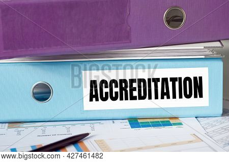 A Lignt Blue Folder With The Label Accreditation.