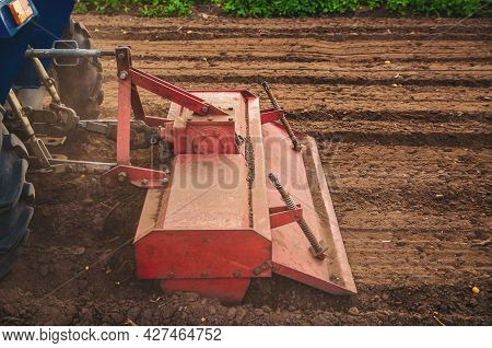 The Tractor Works The Soil Of The Field By Loosening And Mixing It. Softening Of The Soil And Destru