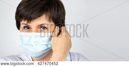 End Coronavirus. End Lockdown. Medical Doctor Removes The Mask From The Face. A Female Doctor Remove