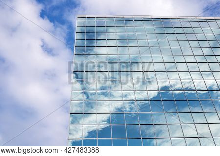 Reflection Of Sky With Clouds In The Glass Building In Downtown