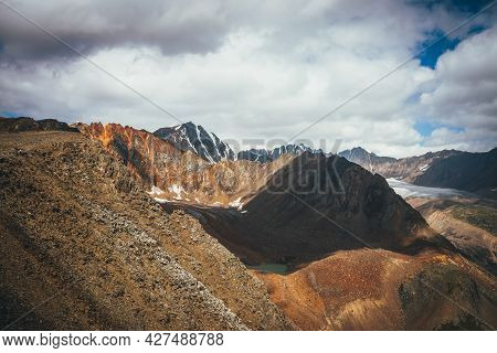 Dramatic Highlands Landscape With Mountain Lake And Glacier Tongue Among Vivid Rocks With Snow. Colo