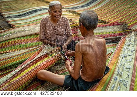 Top View Of Old Vietnamese Lover Craftsman Making The Traditional Vietnam Mats With Happiness Action