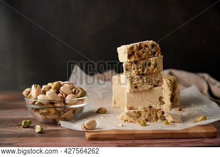 Organic Halva With Pistachios On A Wooden Surface. Traditional Middle Eastern Sweets. Jewish, turkis
