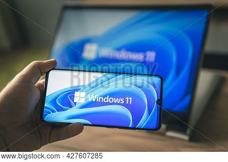 June 23, 2021. Barnaul, Russia. Man With A Laptop And A Smartphone, Windows 11 New Microsoft Operati