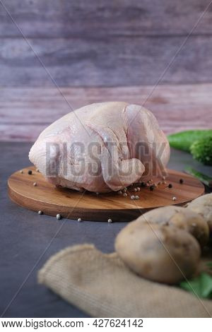 Raw Whole Chicken And Vegetables On A Chopping Board