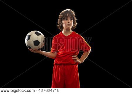 Portrait Of Little Boy, Football Soccer Player Posing With Football Ball Isolated On Dark Studio Bac