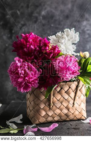 Beautiful Peonies In Wicker Basket On Wooden Table. Peonies Field In Spring. Pink Peonies Flowers. B