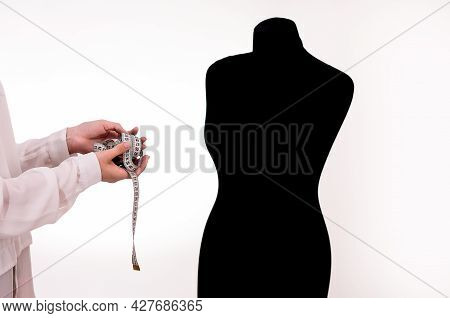 The Seamstresss Hands With A Measuring Ruler Next To The Mannequin.