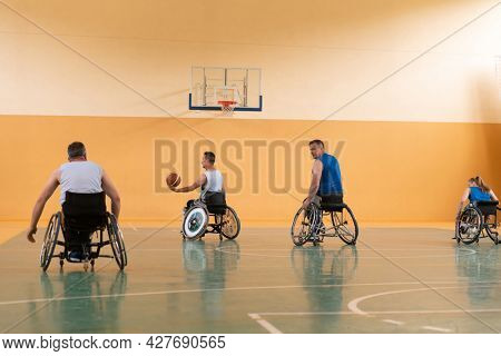 disabled war veterans in action while playing basketball on a basketball court with professional sports equipment for the disabled