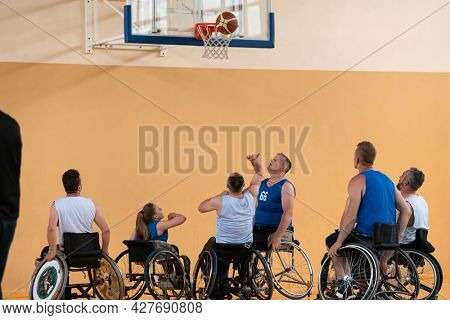 disabled war veterans in action while playing basketball on a basketball court with professional sports equipment for the disabled