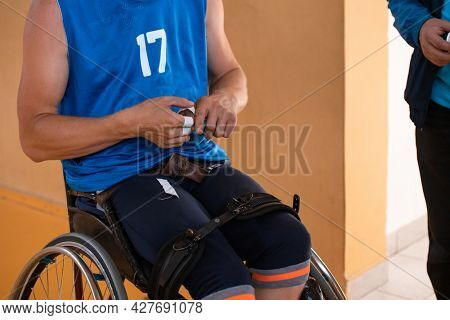 a handicapped basketball player prepares for a match while sitting in a wheelchair.preparations for a professional basketball match. the concept of disability sport