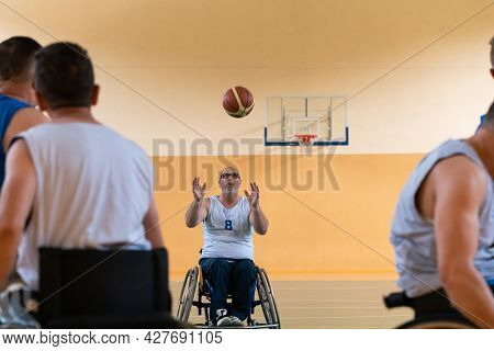 disabled war veterans in action while playing basketball on a basketball court with professional sports equipment for the disabled