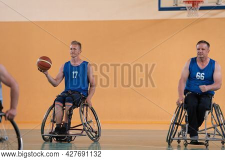 disabled war veterans in action while playing basketball on a basketball court with professional sports equipment for the disabled