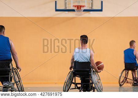 handicapped war veterans in wheelchairs with professional equipment play basketball match in the hall.the concept of sports with disabilities