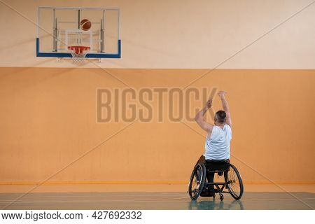 a photo of a war veteran playing basketball with a team in a modern sports arena. The concept of sport for people with disabilities