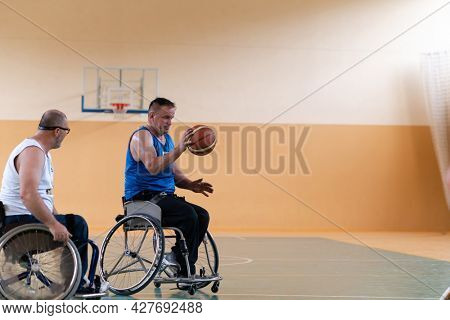 disabled war veterans in action while playing basketball on a basketball court with professional sports equipment for the disabled