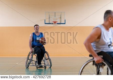 disabled war veterans in action while playing basketball on a basketball court with professional sports equipment for the disabled