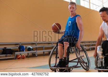 disabled war veterans in action while playing basketball on a basketball court with professional sports equipment for the disabled