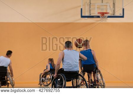 disabled war veterans in action while playing basketball on a basketball court with professional sports equipment for the disabled