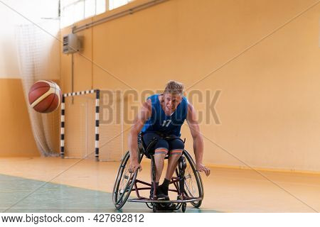 disabled war veterans in action while playing basketball on a basketball court with professional sports equipment for the disabled