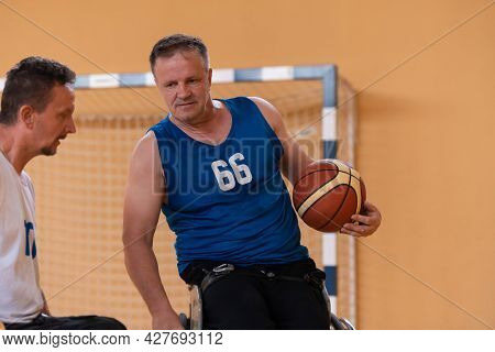 a photo of a war veteran playing basketball with a team in a modern sports arena. The concept of sport for people with disabilities
