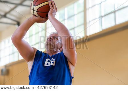 a photo of a war veteran playing basketball with a team in a modern sports arena. The concept of sport for people with disabilities