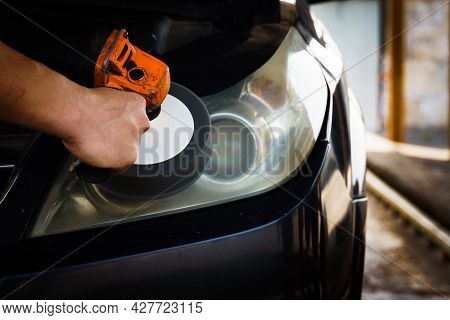 Cleaning Headlights With A Buffer Machine. The Master Polishes The Headlights Of The Car.