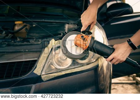 Cleaning Headlights With A Buffer Machine. The Master Polishes The Headlights Of The Car.