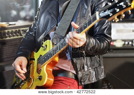 Ung mand spiller elektrisk guitar i studio