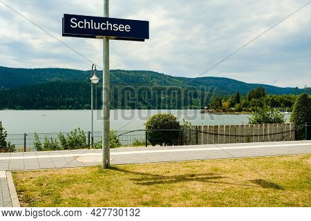 Schluchsee Train Station Nameplate Sign Witht He Schluchsee Lake And Mountains In The Background. Su