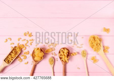Different Types Of Raw Pasta Close-up On A Colored Background.