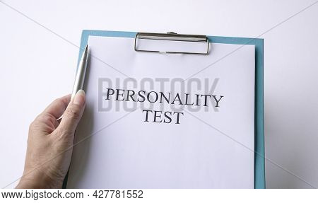 Woman Holding A Pen With Personality Test On Clipboard. On White Background.