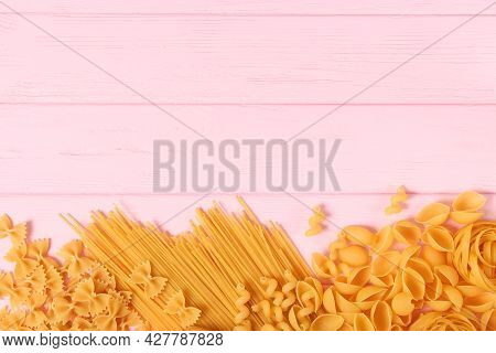 Different Types Of Raw Pasta Close-up On A Colored Background.
