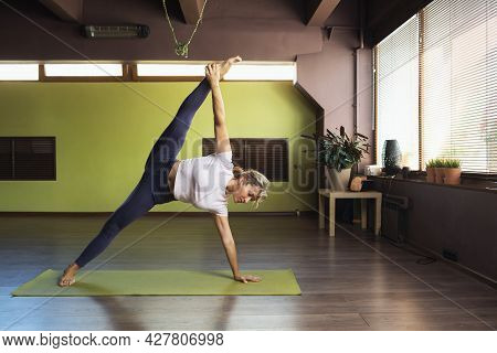 A Woman Leading A Healthy Lifestyle, Doing Yoga, Performs In The Studio The Exercise Vasishthasana, 