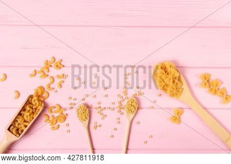 Different Types Of Raw Pasta Close-up On A Colored Background.