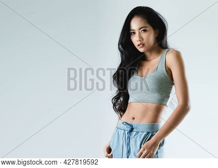 Asian Woman With Sexy Shapely Forms Posing In Trendy Look. Portrait Of A Brunette Model With Bright 