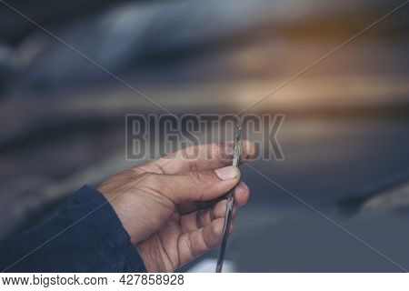 Car Mechanic Man Hand Checking Dipstick Engine Oil Car Mechanical On Site Service. Close Up Hand Man