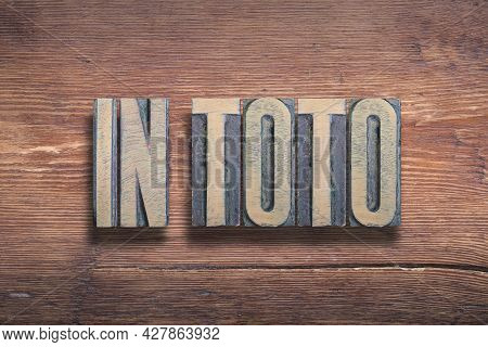In Toto Ancient Latin Saying Meaning - As A Whole, Combined On Vintage Varnished Wooden Surface