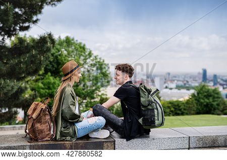 Young Couple Travelers With Map In City On Holiday, Resting And Planning.