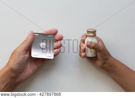 Top View Of Woman Hand Holding Tablet And Woman Hand Holding Tube With Medicine On The White Backgro