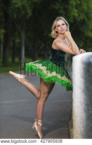 Young Professional Caucasian Ballet Dancer In Green Tutu Dress And Artistic Crown Posing Between Two