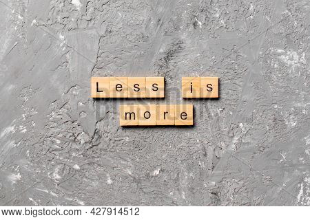 Less Is More Word Written On Wood Block. Less Is More Text On Table, Concept