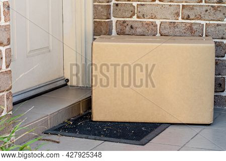 Parcel Box Delivered To A Front Door Of Residential Building. Online Shopping And Delivery. Post Shi