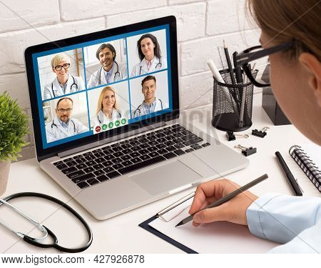 Female Doctor Having Meeting With Colleagues Via Video Call Indoor