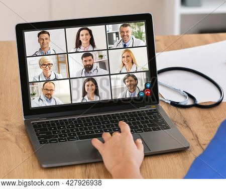 Doctor Video Calling Communicating With Group Of Colleagues Indoor, Cropped