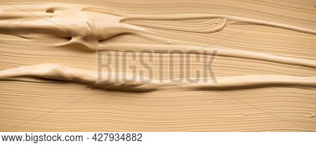 Foundation, concealer, face makeup smudge, smears. Cosmetic liquid foundation or cream beige color smudges, stroke. Contouring, Make up smears background. Foundation texture surface