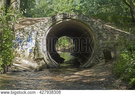 Little River Flows In A Pipe Under The Bridge. Toppers River Chartenovka, Bitsevsky Forest, Moscow, 
