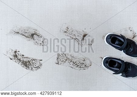 Dirty Shoes Leaving Muddy Footprints On Carpet. Top View. High Quality Photo