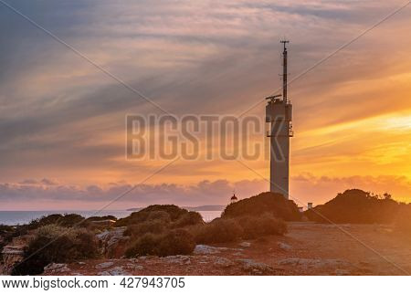Lighthouse of Ponta do Altar on sunset sky background. Ferragudo, Lagoa, Algarve, Portugal