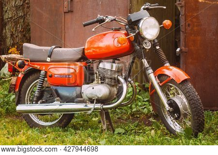 Minsk, Belarus - September 22, 2013: Old Red Russian Soviet Motorcycle Parked On Green Grass Yard. T